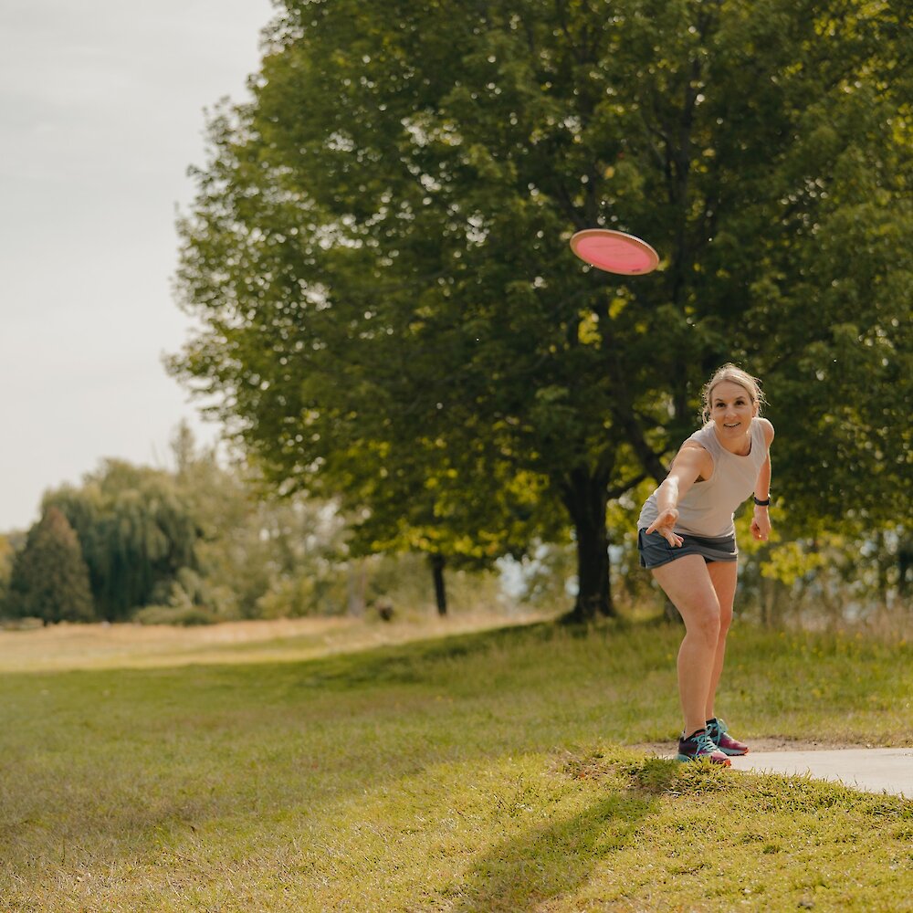 Woman throwing a disc at the McArthur Island Park Disc Golf Course on the North Shore in Kamloops, BC.