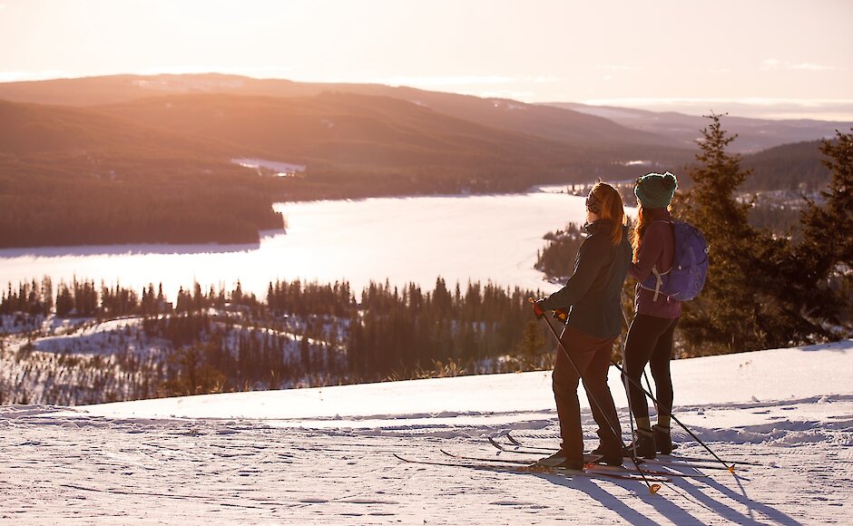 Cross country skiiers admiring the winter view of Stake Lake, skiing with Overlander Ski Club in Kamloops, BC.