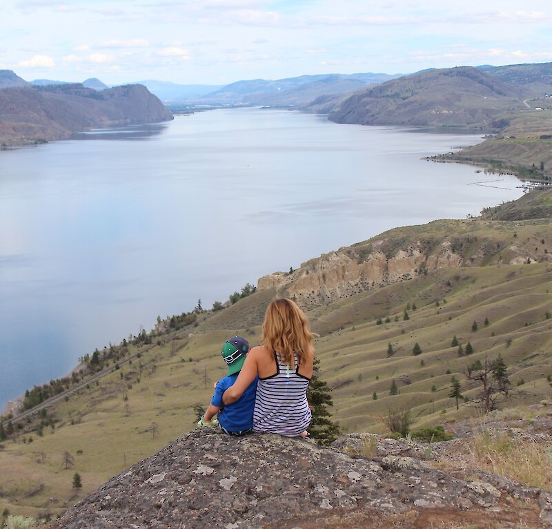 A Mother and son admiring the view over Kamloops Lake from a hiking viewpoint in Kamloops, BC.