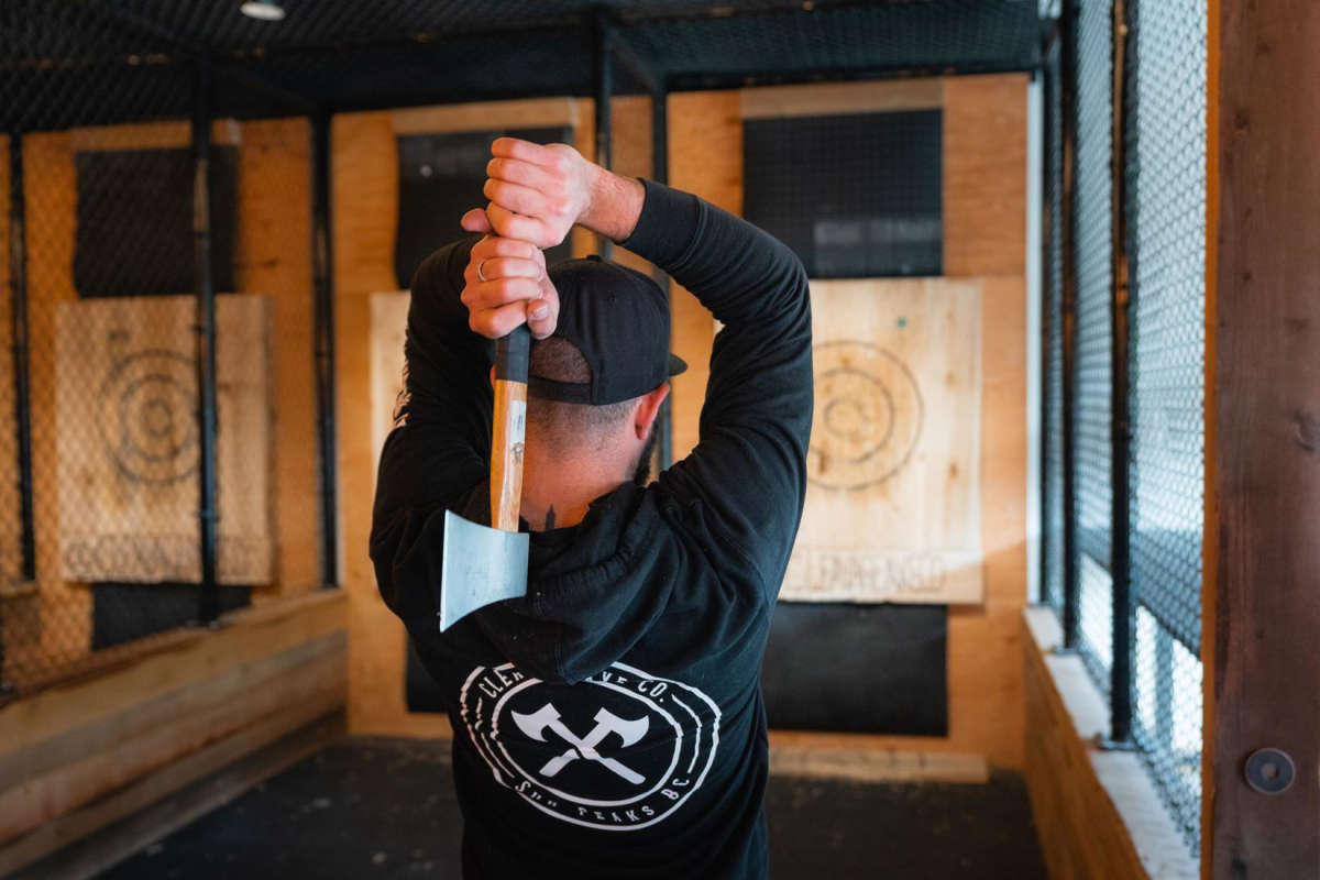 Man throwing axe at a wooden target at Cleavage Axe Co in Sun Peaks, BC.