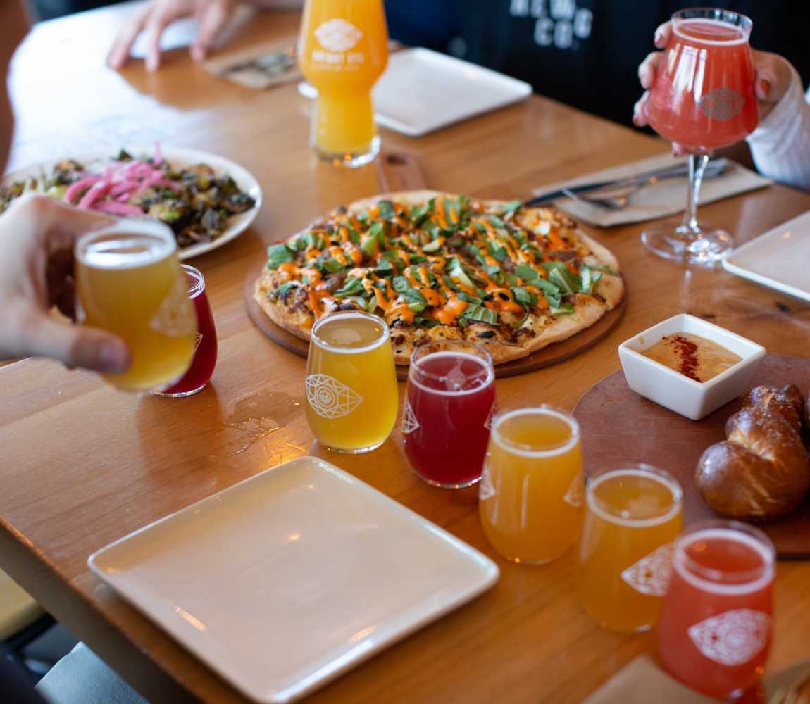 A restaurant table filled with a craft beer flight and food at Bright Eye Brewing in Kamloops, BC.