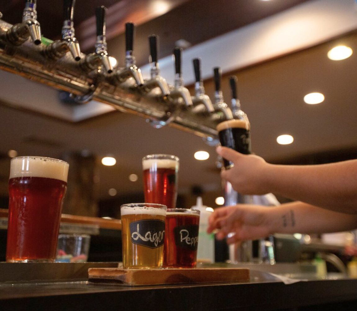 Brewhouse staff filling up a beer flight at Noble Pig Brewhouse in Kamloops, BC.