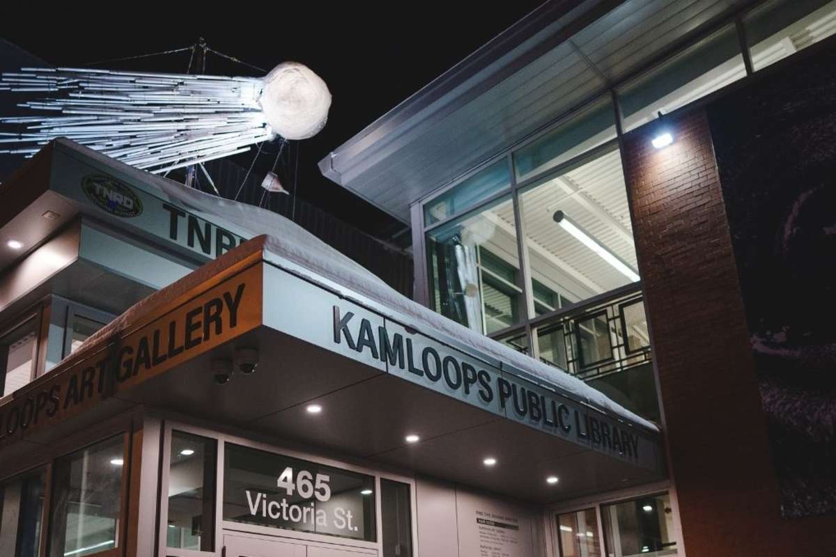 outside of a building with a comet art installation on the roof