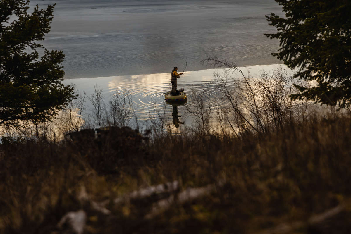 Man casting from an inflatable boat on the lake in Kamloops, BC.