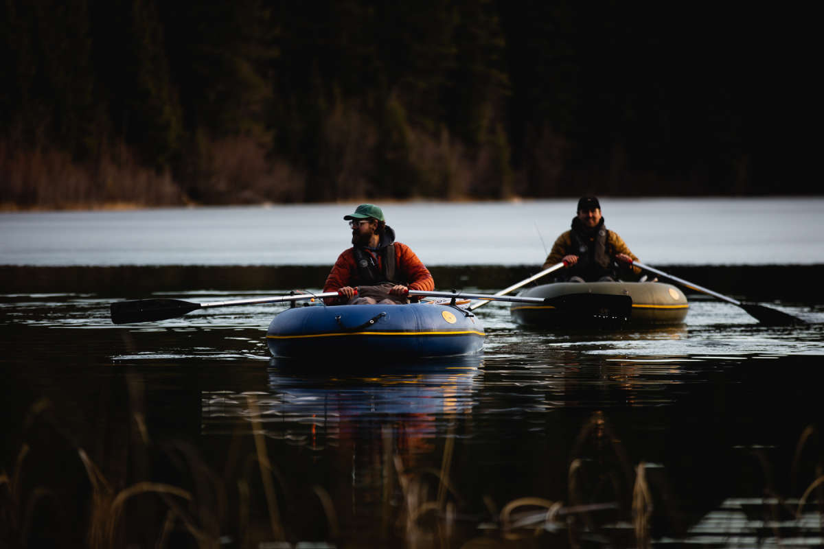 two men rowing boat out on the lake for ice off fishing in Kamloops, BC.