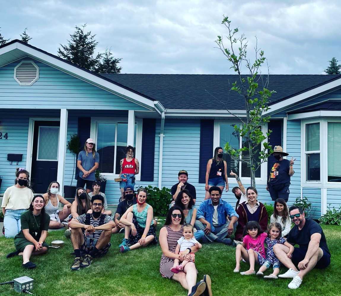 group of individuals standing outside a home for a movie set