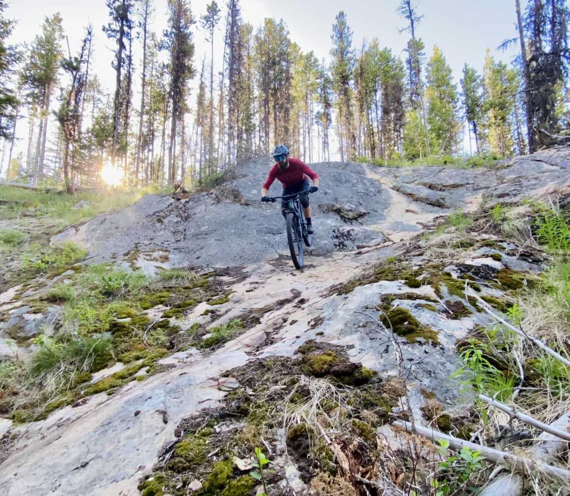 Mountain biker riding down a roadface at Stake Lake in Kamloops, BC.