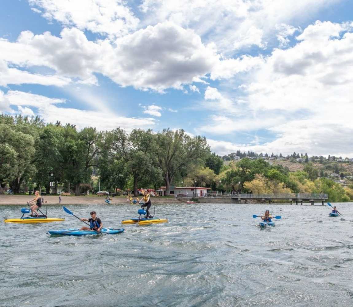 folks kayaking and water biking on the South Thompson River at Riverside Park