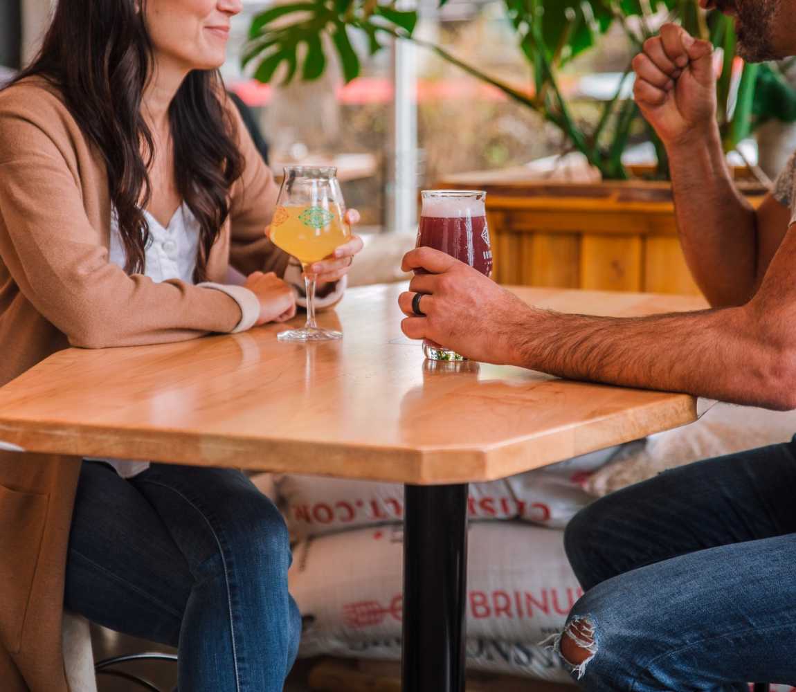 A couple enjoying cold beer drinks at Bright Eye Brewing in Kamloops, BC.