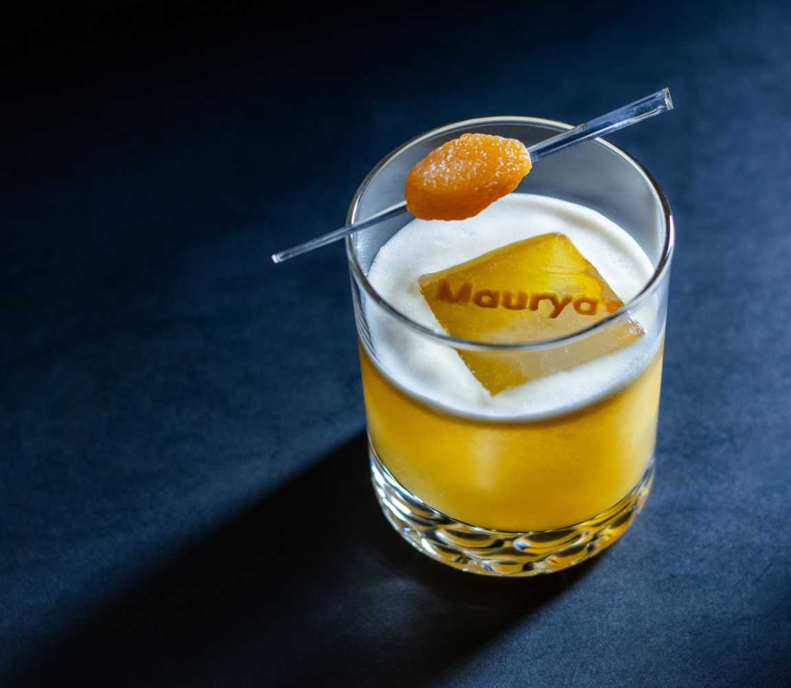 A artfully crafted cocktail drink with Maurya's written on the top of the drink