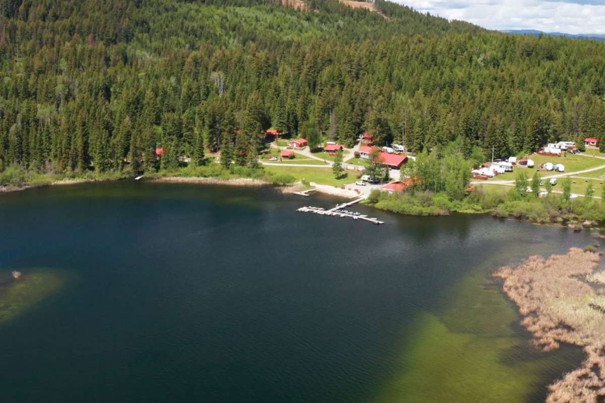 knouff lake wilderness resort with a red roof amongst a blue lake