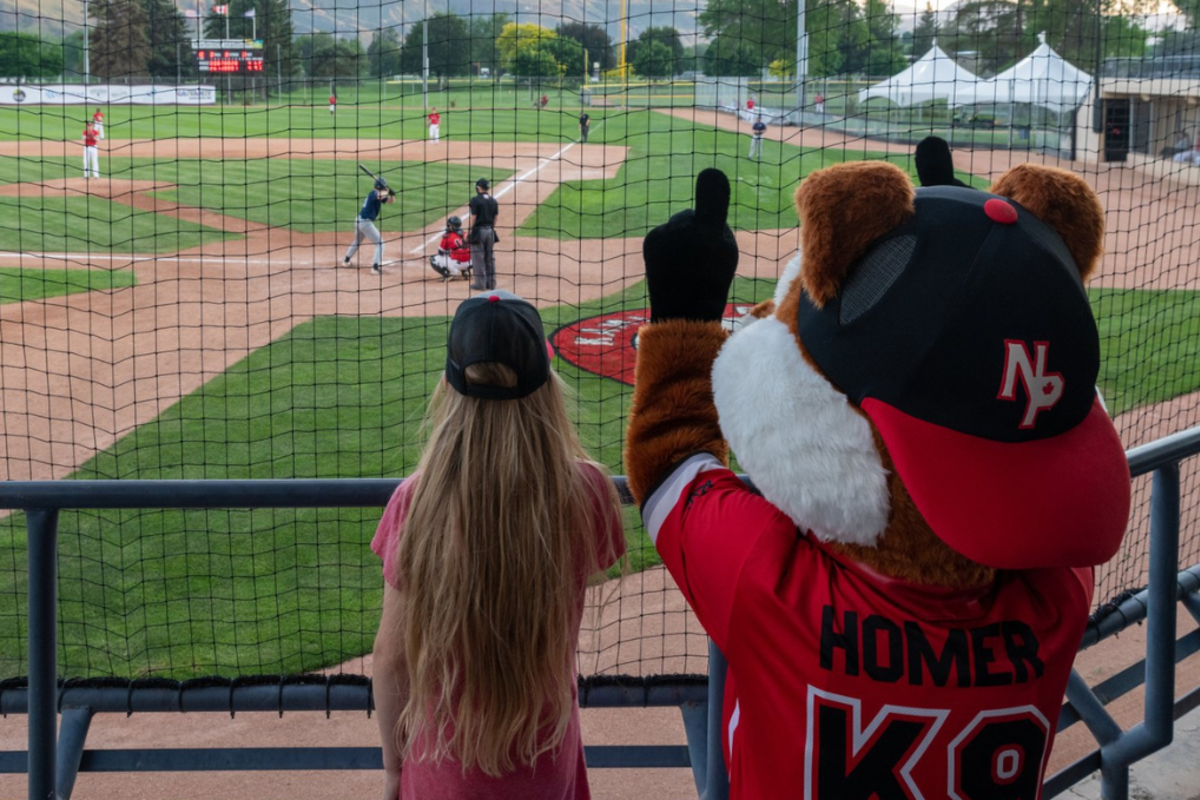 Fan at a NorthPaws Baseball Game with Homer the mascot at Norbrock Stadium located in Kamloops, British Columbia.