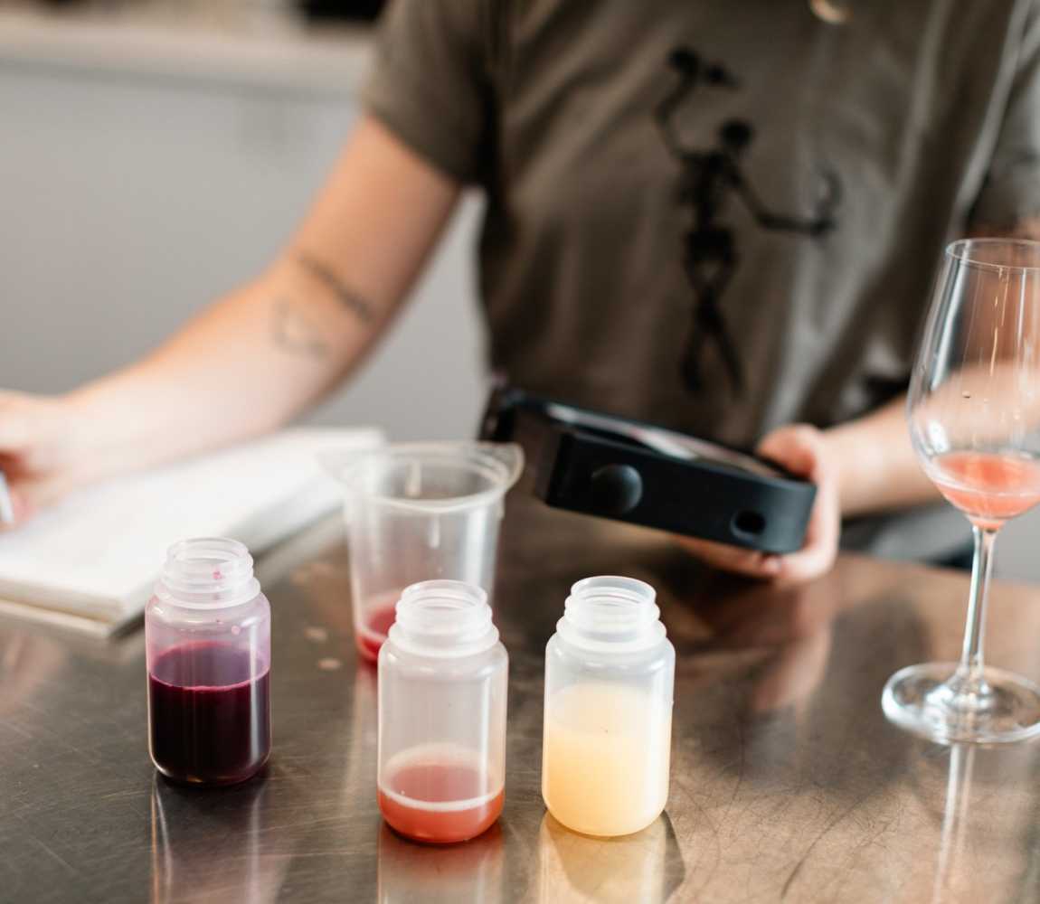 Woman measure different aspects of wine at Monte Creek in Kamloops, BC.