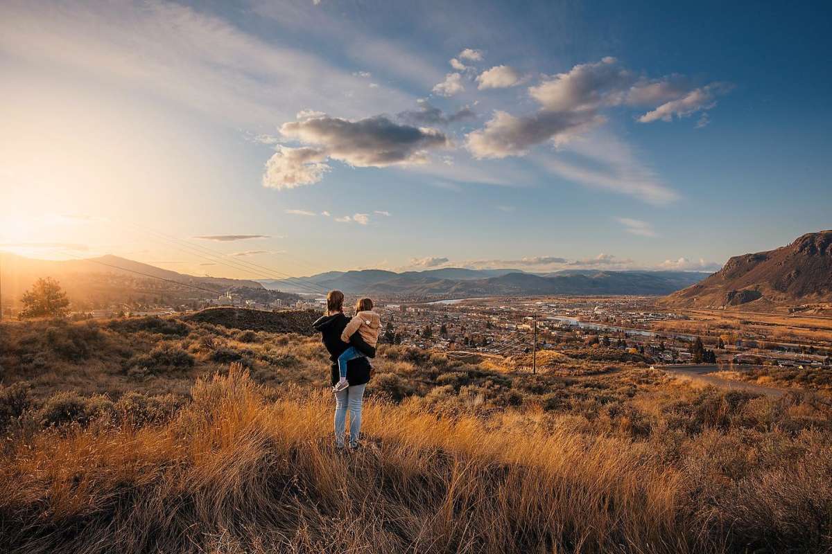 Mom holding daughter in the grasslands overlooking Kamloops, BC.