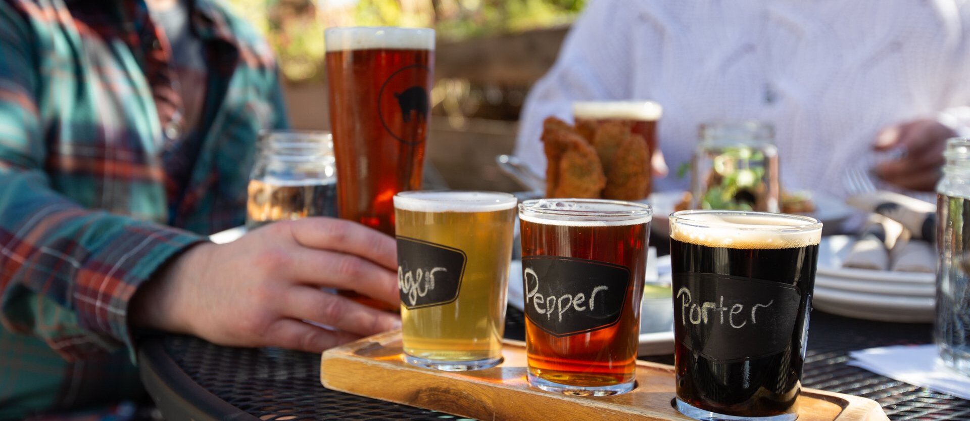 Friends enjoy a flight of amazing beer at the Noble Pig in Kamloops British Columbia