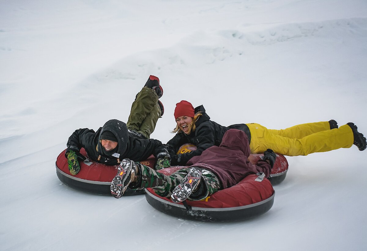 Three people ride tubes down a snowy hill at Harper Mountain, near Kamloops BC