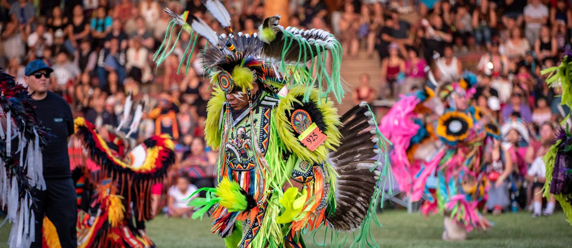 Dancer dressed in vibrant colours at the Kamloopa Powwow at  the Special Events Facility (the Arbour) within Secwepemcúl’ecw, British Columbia.