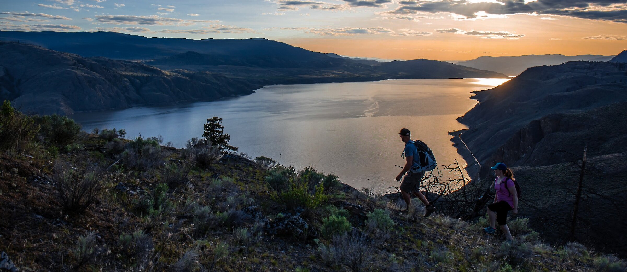 Two hikers overlooking Kamloops Lake from Battle Bluff in Kamloops, BC.