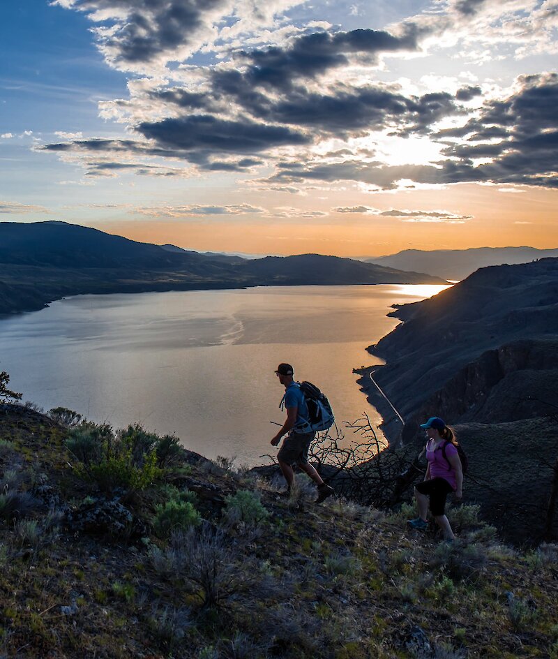 Two hikers overlooking Kamloops Lake from Battle Bluff in Kamloops, BC.