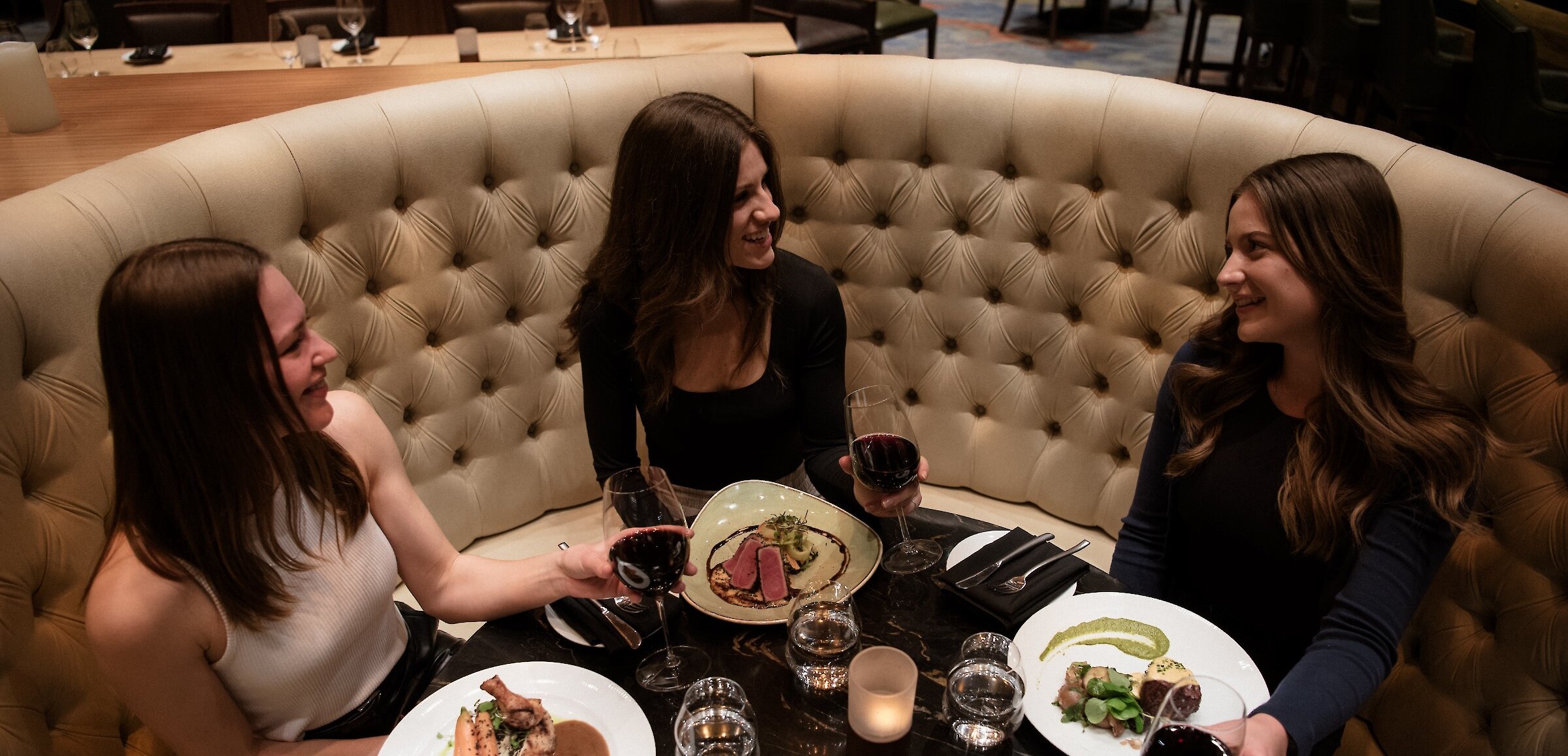 Three woman enjoying their meals at Atlas Steak + Fish during Dine Around in Kamloops, BC.