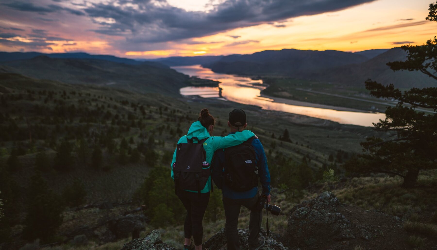 Two Hikers admiring the sunset in Kenna Cartwright Park in Kamloops BC.