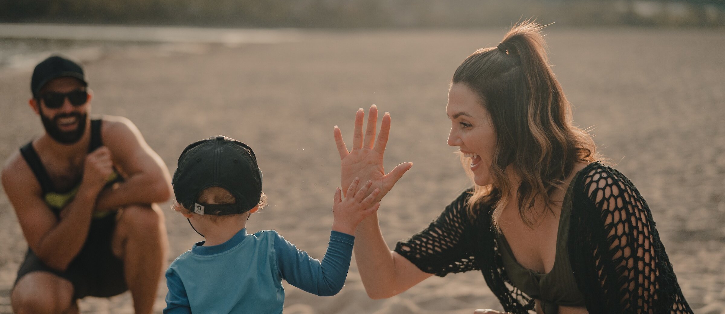 Mom giving a high-five to her son at the Overlander Park beach at Kamloops, BC.