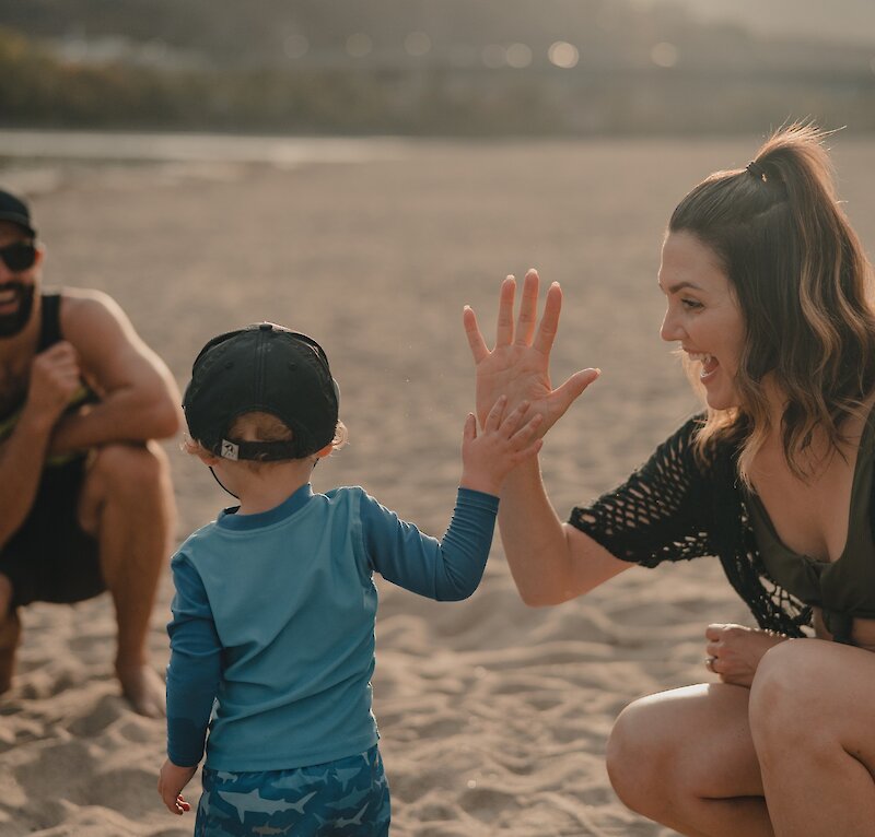 Mom giving a high-five to her son at the Overlander Park beach at Kamloops, BC.