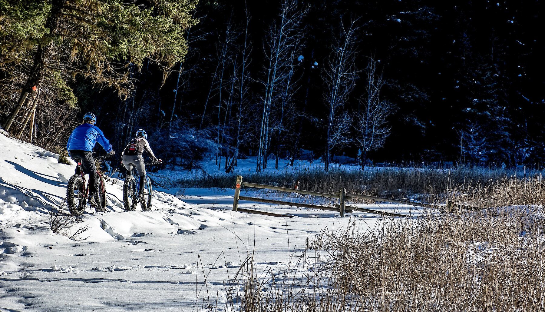 Couple winter biking at Isobel Lake in Kamloops, BC.