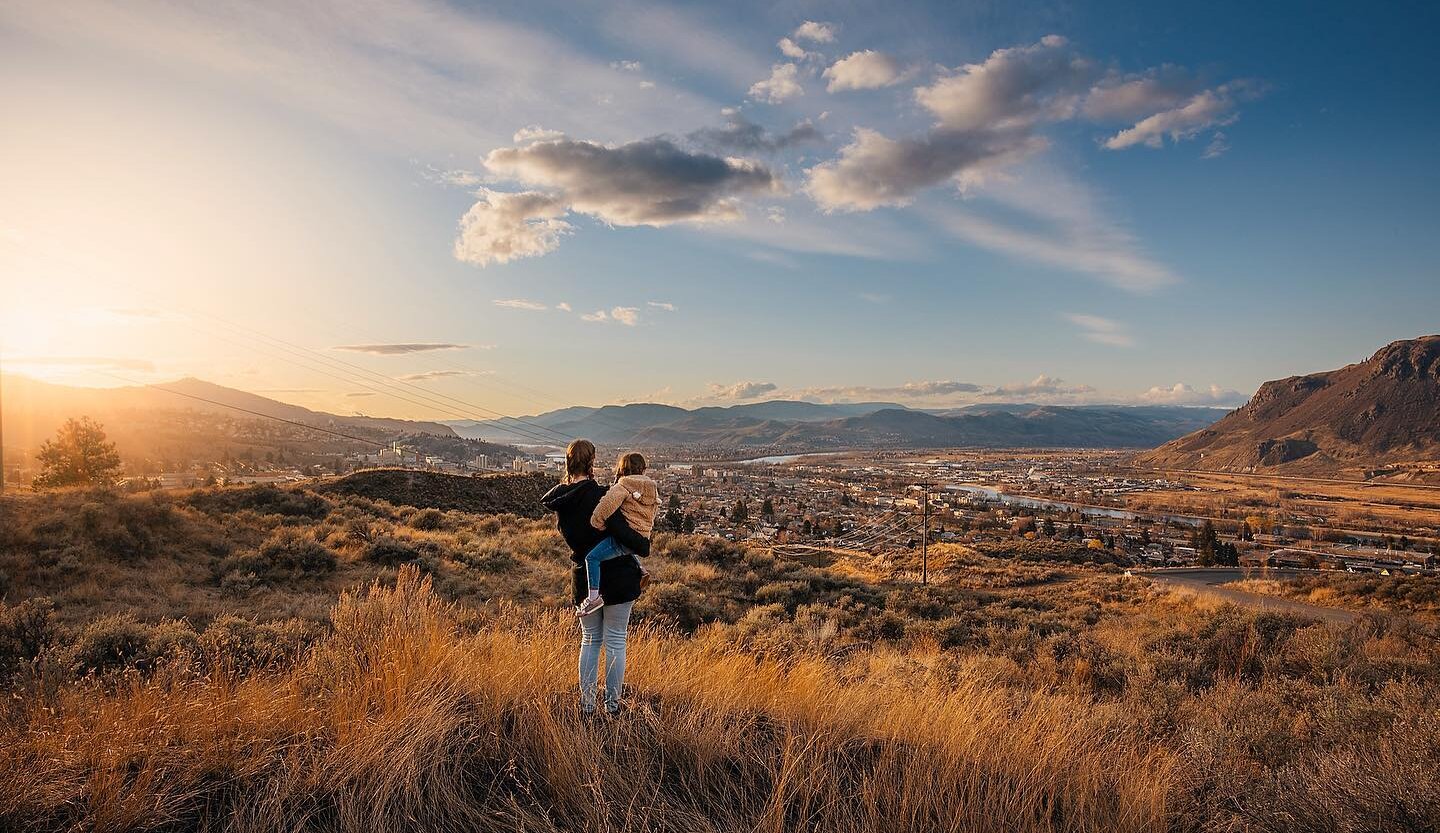 Mother and daughter outdoor hiking admiring the view over Kamloops.