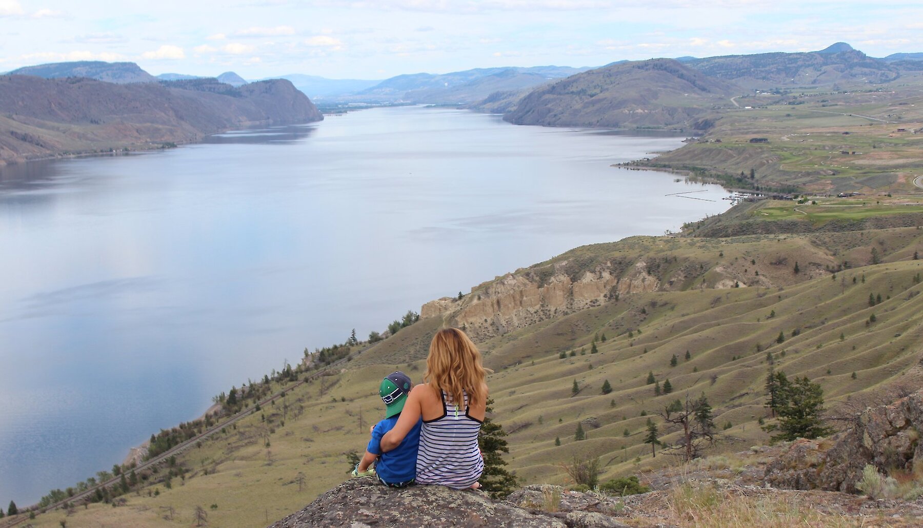 A mother and son looking out over a stunning viewpoint over Kamloops Lake, BC.