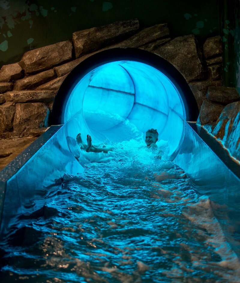 Boy enjoying the waterslide at the Canada Games Aquatic Centre located in the Tournament Capital Centre in Kamloops, BC.