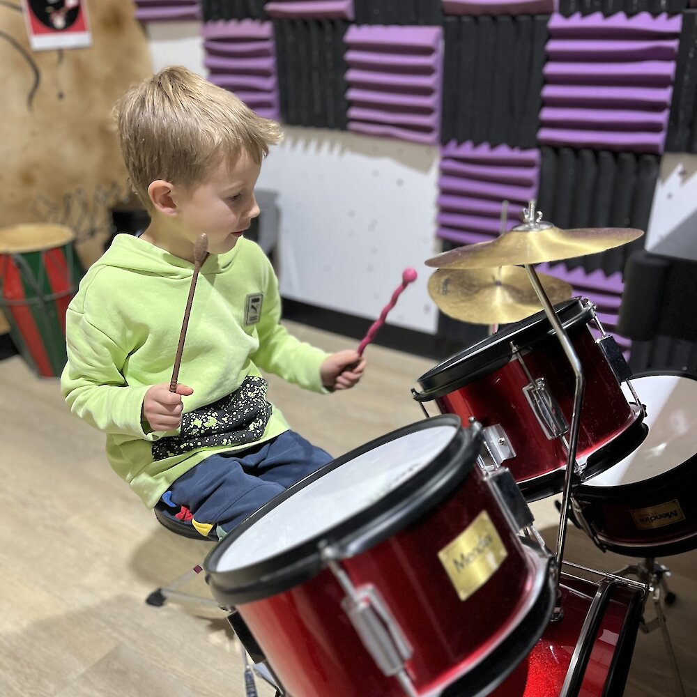 Boy playing a drum set at Zaaz Eatery & Play in Kamloops, BC.