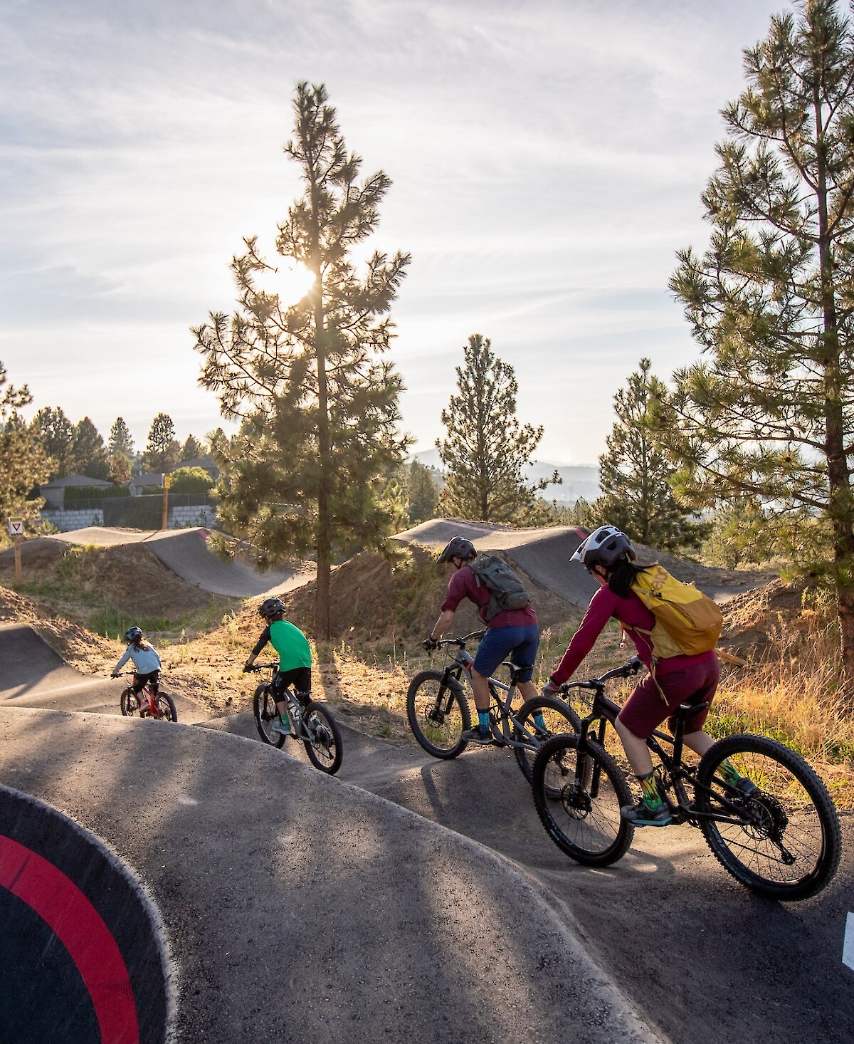 Family riding the Pump Track at the Kamloops Bike Ranch in BC.