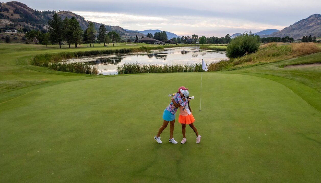 Two women embrace on a golf green at Rivershore Golf Course in Kamloops BC.