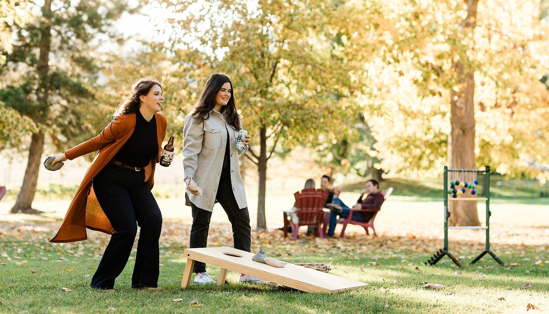 Two women participate in a cornhole tournament at Woodward Cider Co.