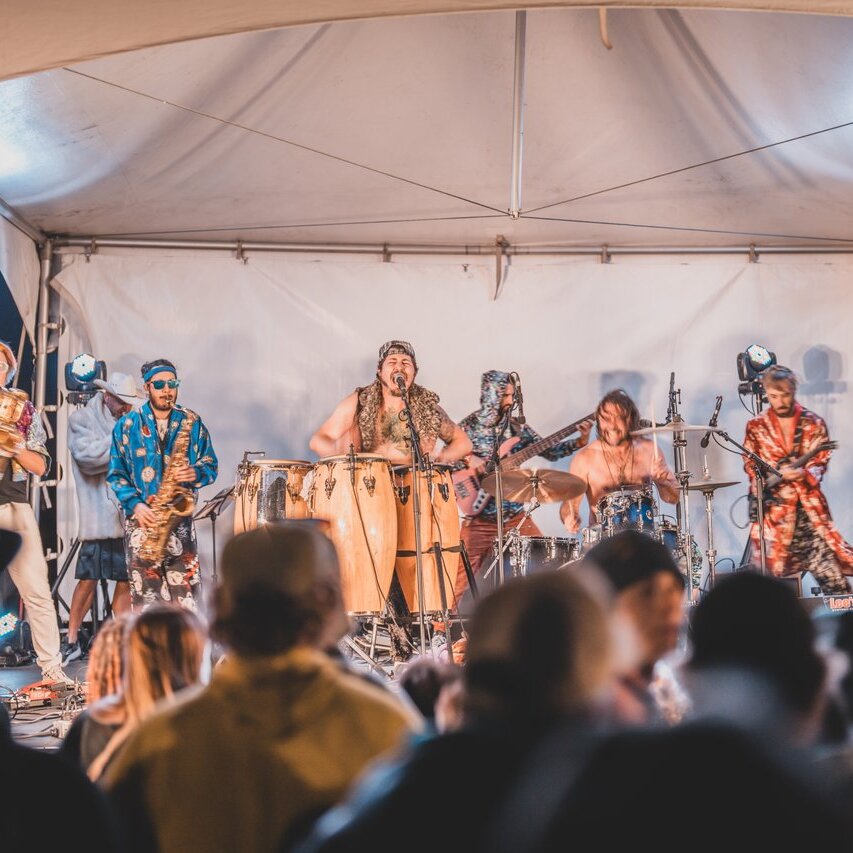 A band performed on a brightly lit stage under a tent at Harper Mountain's Oktoberfest event