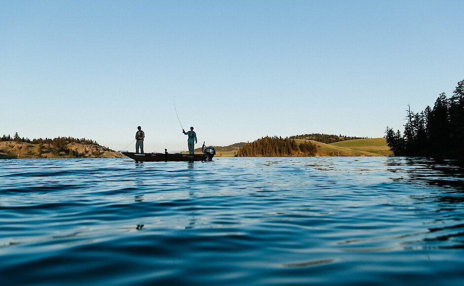 Two fishermen casting from their boat.