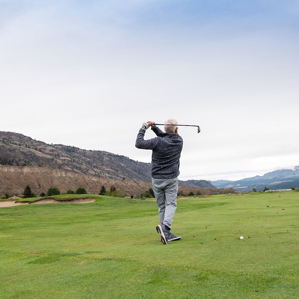 Man practicing his swing on the golf course at Rivershore Estate & Golf Links in Kamloops, British Columbia.