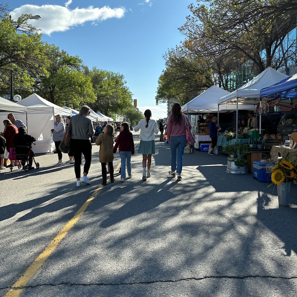 Women with their kids walking through the Regional Farmers' Market in downtown Kamloops, British Columbia.