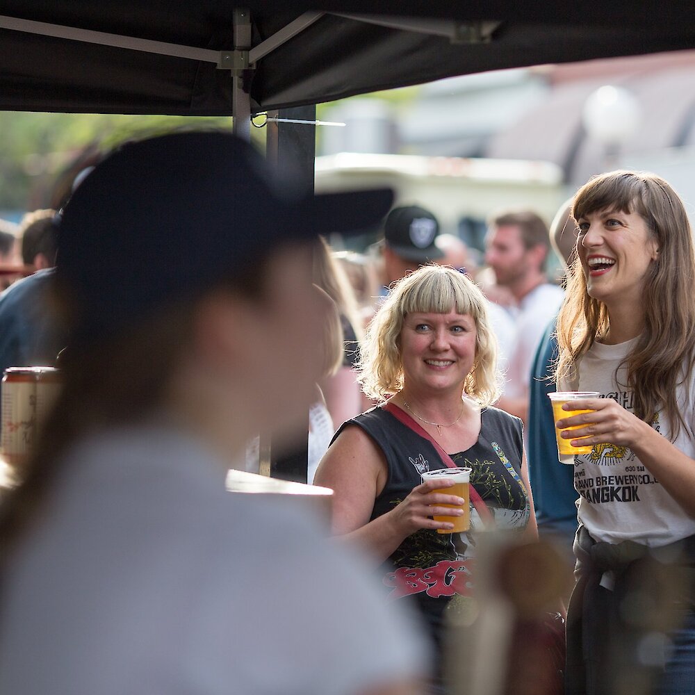 Two women holding their craft beer at the Brewloops event in Kamloops, British Columbia.