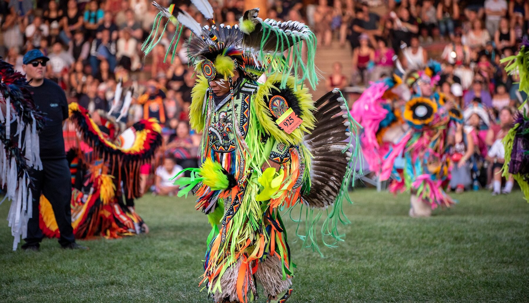 Dancer dressed in vibrant colours at the Kamloopa Powwow at  the Special Events Facility (the Arbour) within Secwepemcúl’ecw, British Columbia.