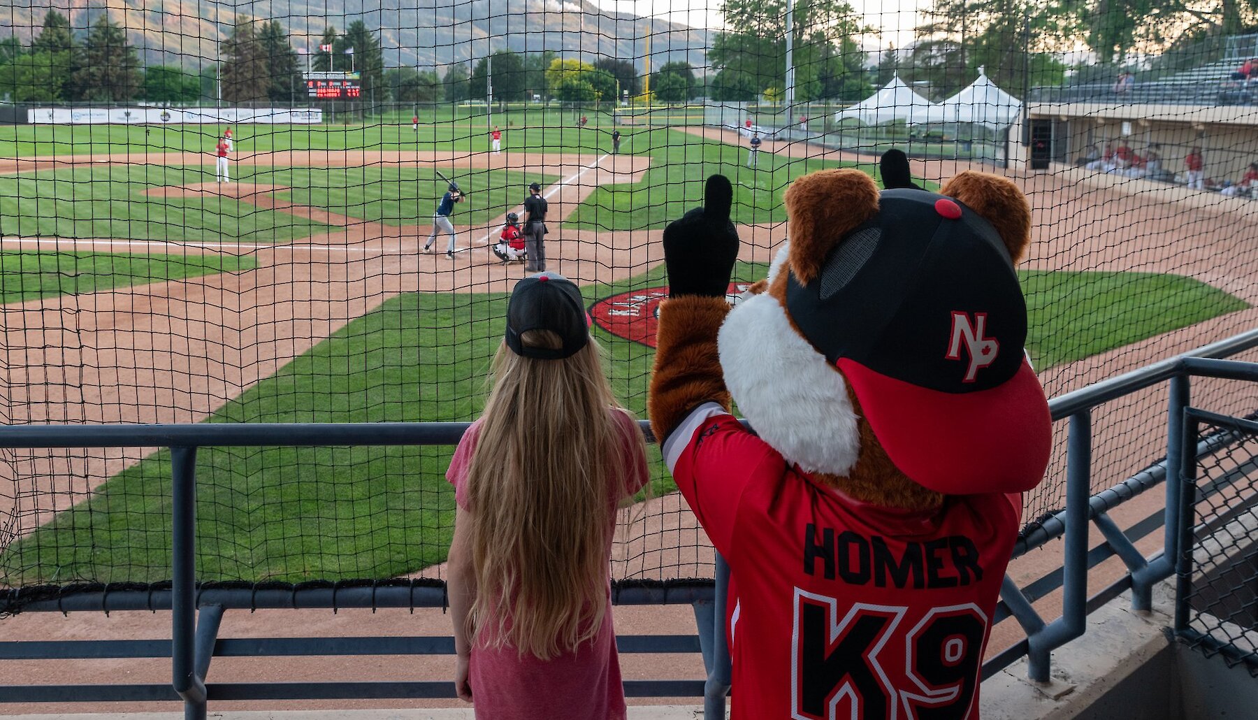 Fan at a NorthPaws Baseball Game with Homer the mascot at Norbrock Stadium located in Kamloops, British Columbia.