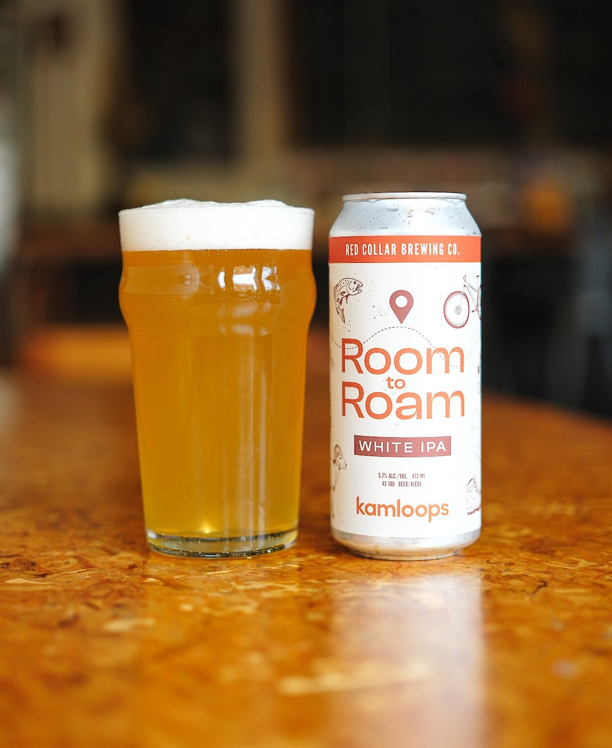 Pint of Room to Roam White IPA with a can beside it in the Red Collar Brewing Taproom located in Kamloops, BC.