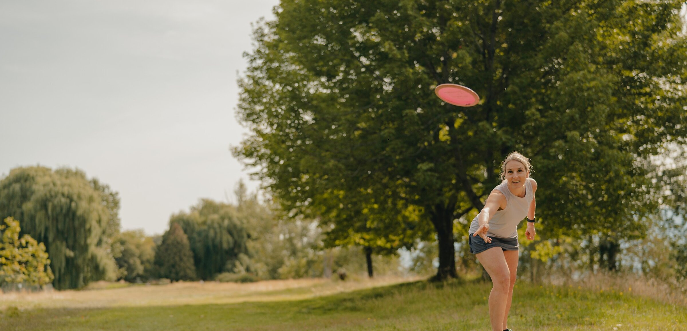 Woman throwing a disc at the McArthur Island Park Disc Golf Course on the North Shore in Kamloops, BC.