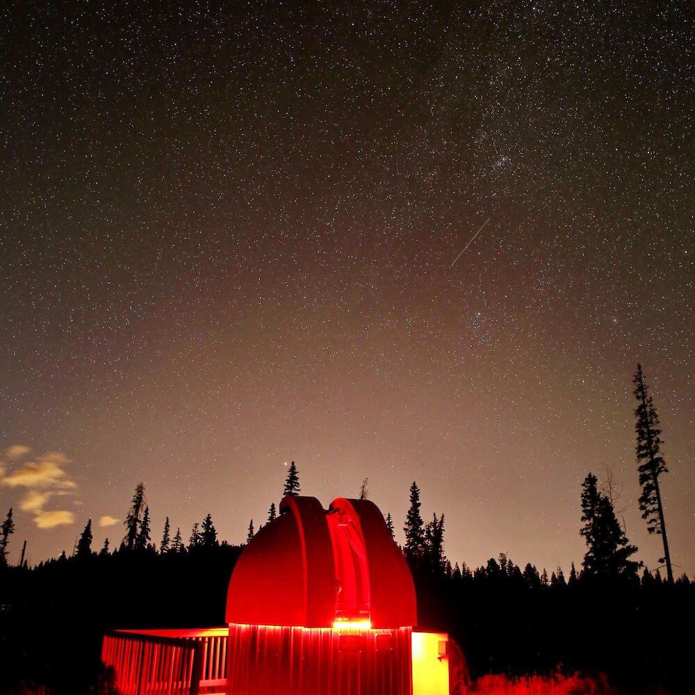 The Kamloops Astronomical Society Observatory lit up with red light underneath the starry sky at Stake Lake near Kamloops, British Columbia