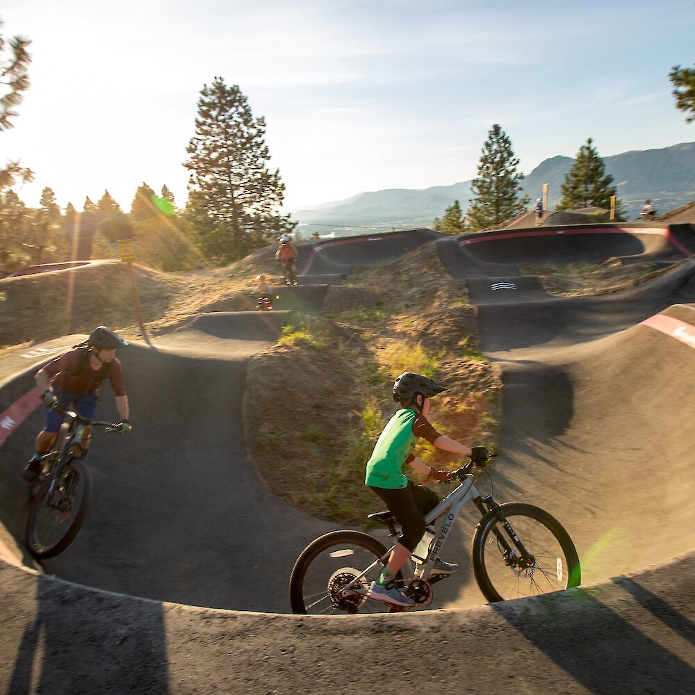 Family riding the new all-wheels pump track at the Kamloops Bike Ranch in Kamloops, British Columbia.