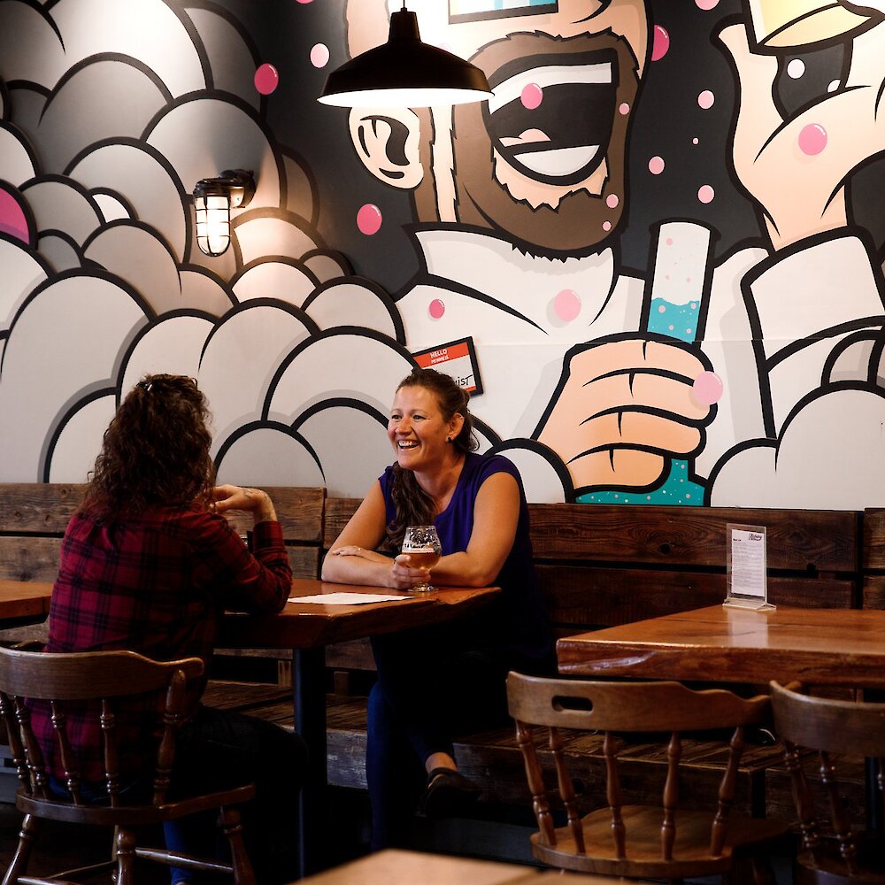 Two women enjoying their brews at Alchemy Brewing in downtown Kamloops, BC.