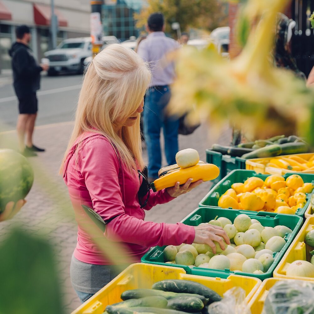 A market-goer shopping through the fresh local produce at the Kamloops Farmers Market.