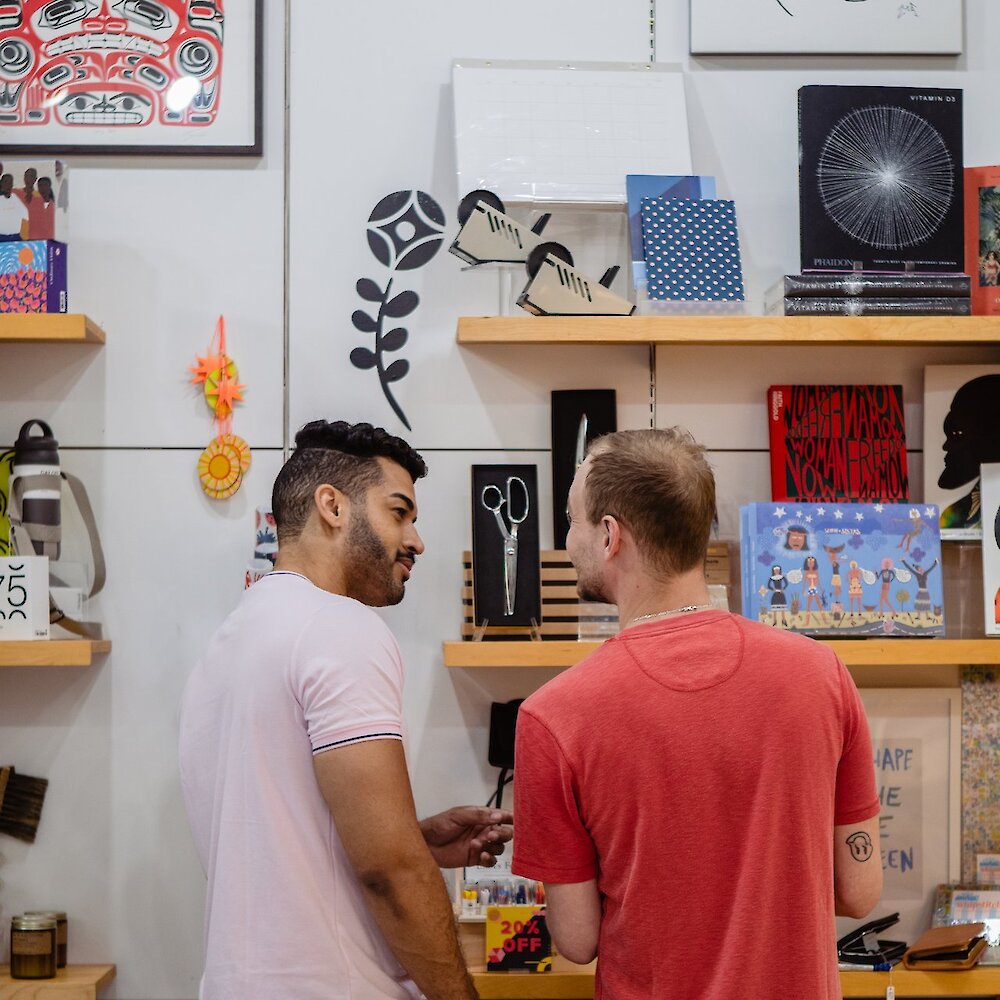 Two men shopping through unique items at the Kamloops Art Gallery Store.