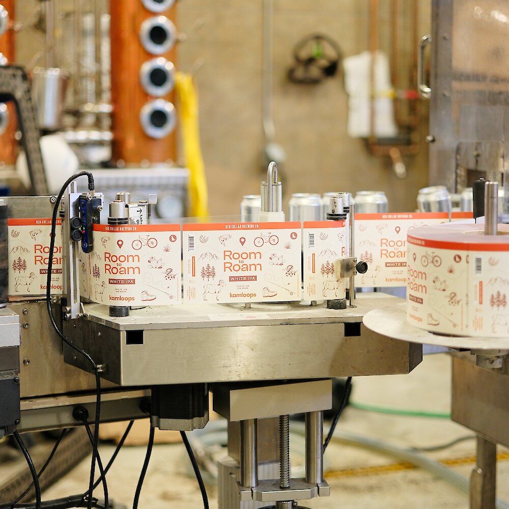 The beer canning labels of the Room to Roam White IPA going through the production line at Red Collar Brewing in downtown Kamloops, BC.